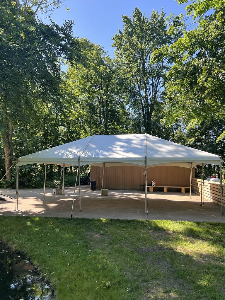 a large white event tent set up on grass with a stage.